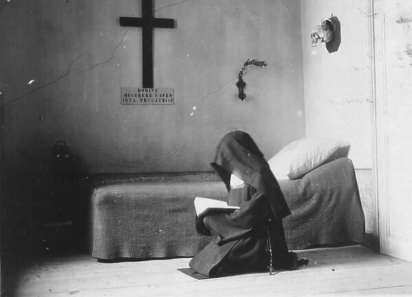 Carmelite. 1904: A Carmelite nun reading in her cell