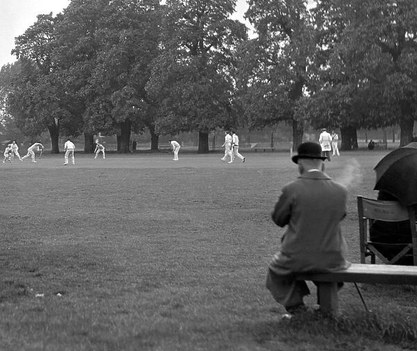 Man watching the cricket and smoking, Ham & Hampton Wick. 2359a