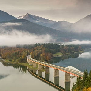 Sylvenstein Lake and bridge surrounded by the morning mist. Bad Tolz-Wolfratshausen district, Bavaria, Germany