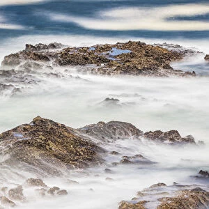 Shore Acres State Park, Oregon, USA. Blur of waves flowing over rocks