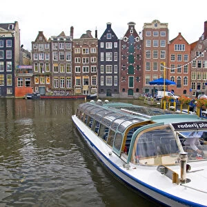 A tour boat waiting at Rederij Plas dock on a canal lined with colorful gabled homes