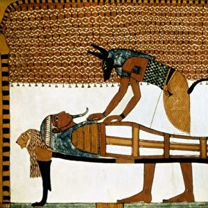 ANCIENT EGYPT: ANUBIS. The god Anubis mummifies a dead body