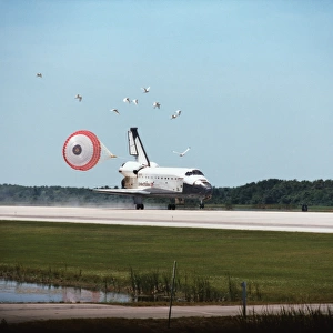 The space shuttle landing with its drogue parachute deployed