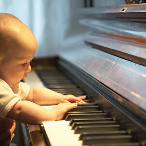 Baby, 4-5 months old, at a piano, Germany