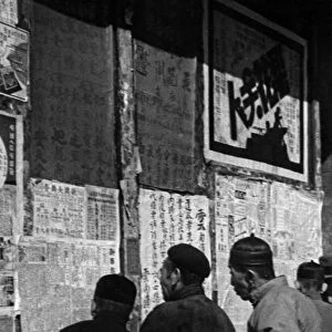 Chinese people reading news of the war on a notice board, Yunnan-Fu, c. 1946 (b / w photo)