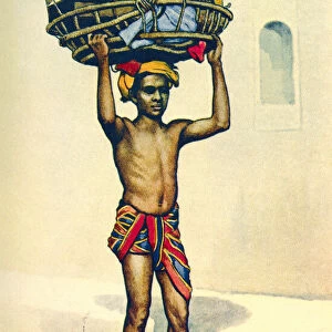 An Indian porter carrying a large basket of luggage on his head, India, from a contemporary print, c. 1935; Artwork