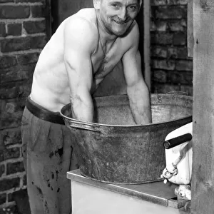 Edward Robson washing in an old tin bath. This will probably be the ast time he will use