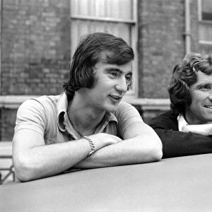 England Players: Alan Hudson and Alan Ball leaning on a car top watching the World go by