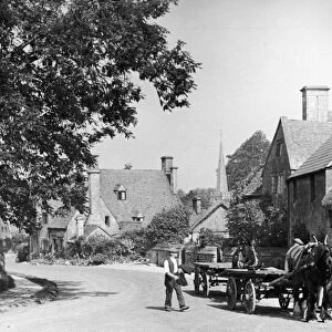 Man with his horse and cart on a country road in the Cotswold village of Stanton