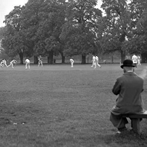 Man watching the cricket and smoking, Ham & Hampton Wick. 2359a