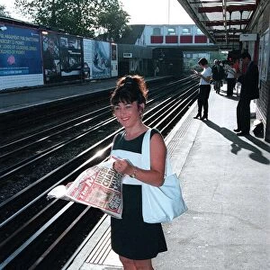 Maria Smedley actress reading copy of Daily Mirror Newspaper while standing