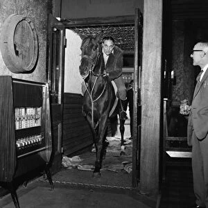Mr Leslie Johnson rides his horse "Lady"into the bar of the Fox and Goose
