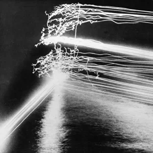 Tracer bullets light up the night sky as guns from a US Navy warship pout their fire on a